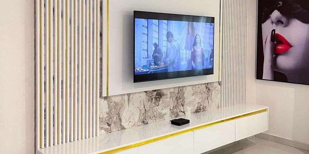 White and gold fluted panel media wall with marble detailing by Shivin Interiors, Nairobi